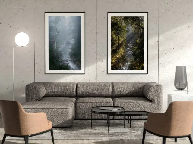 Two large portrait orientation images of rivers mounted on a concreete wall behind an L-shaped couch in a living room.